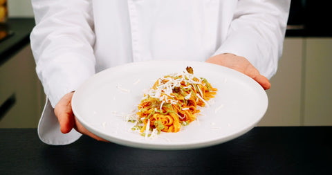 Tagliatelline all'uovo con il ragù di agnello, crema di carciofi e scaglie di ricotta affumicata