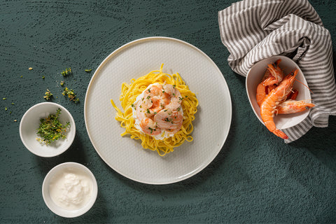piatto di tagliatelline con gamberi alle erbe aromatiche e stracciatella